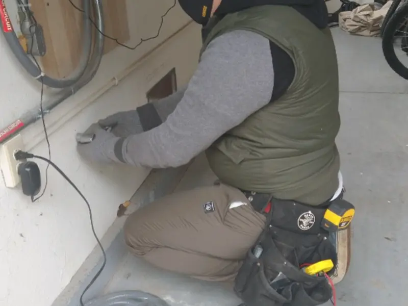 Electrician performing outlet wiring in a Westfall garage